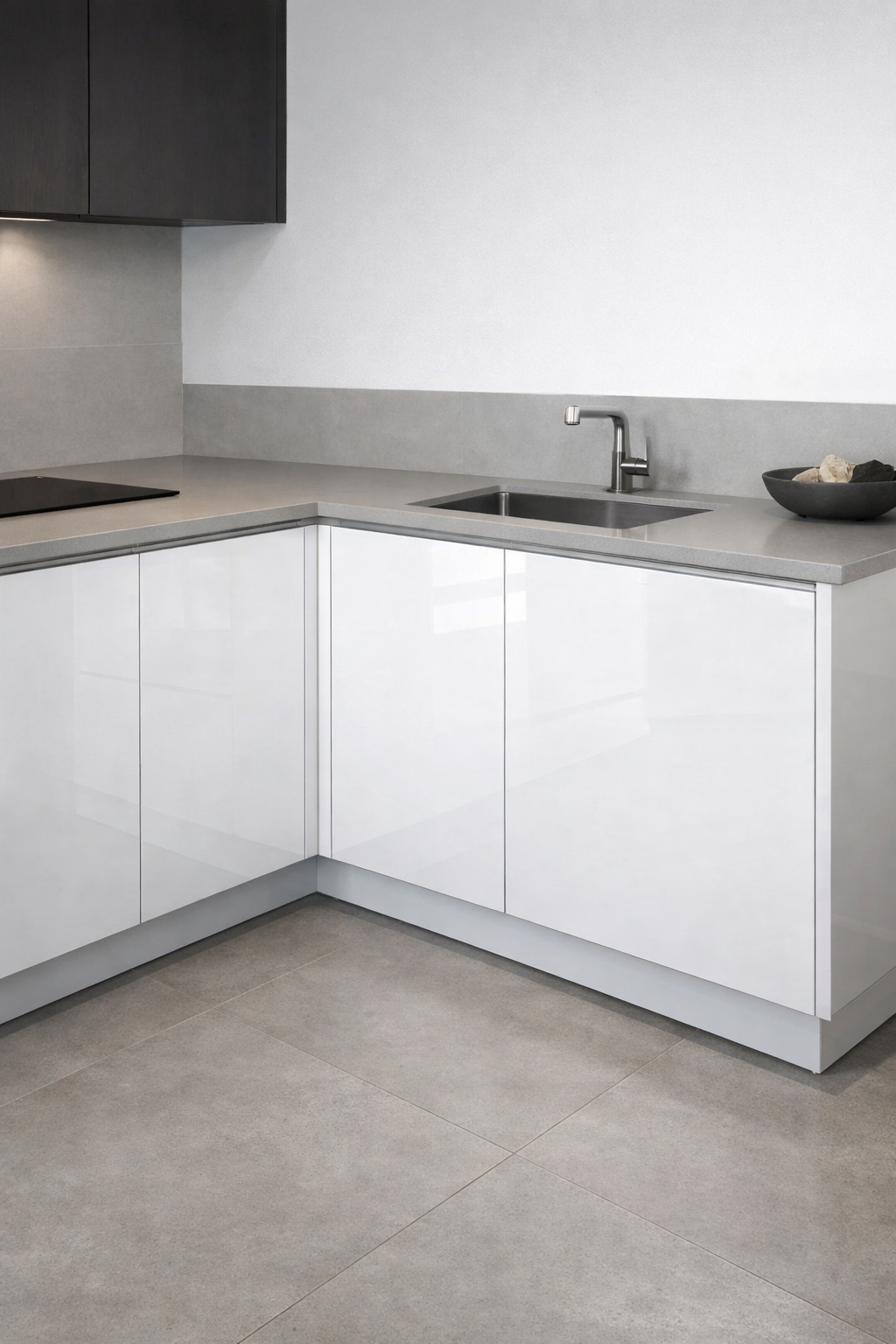 Modern corner kitchen cabinet with white glossy finish and gray countertop.